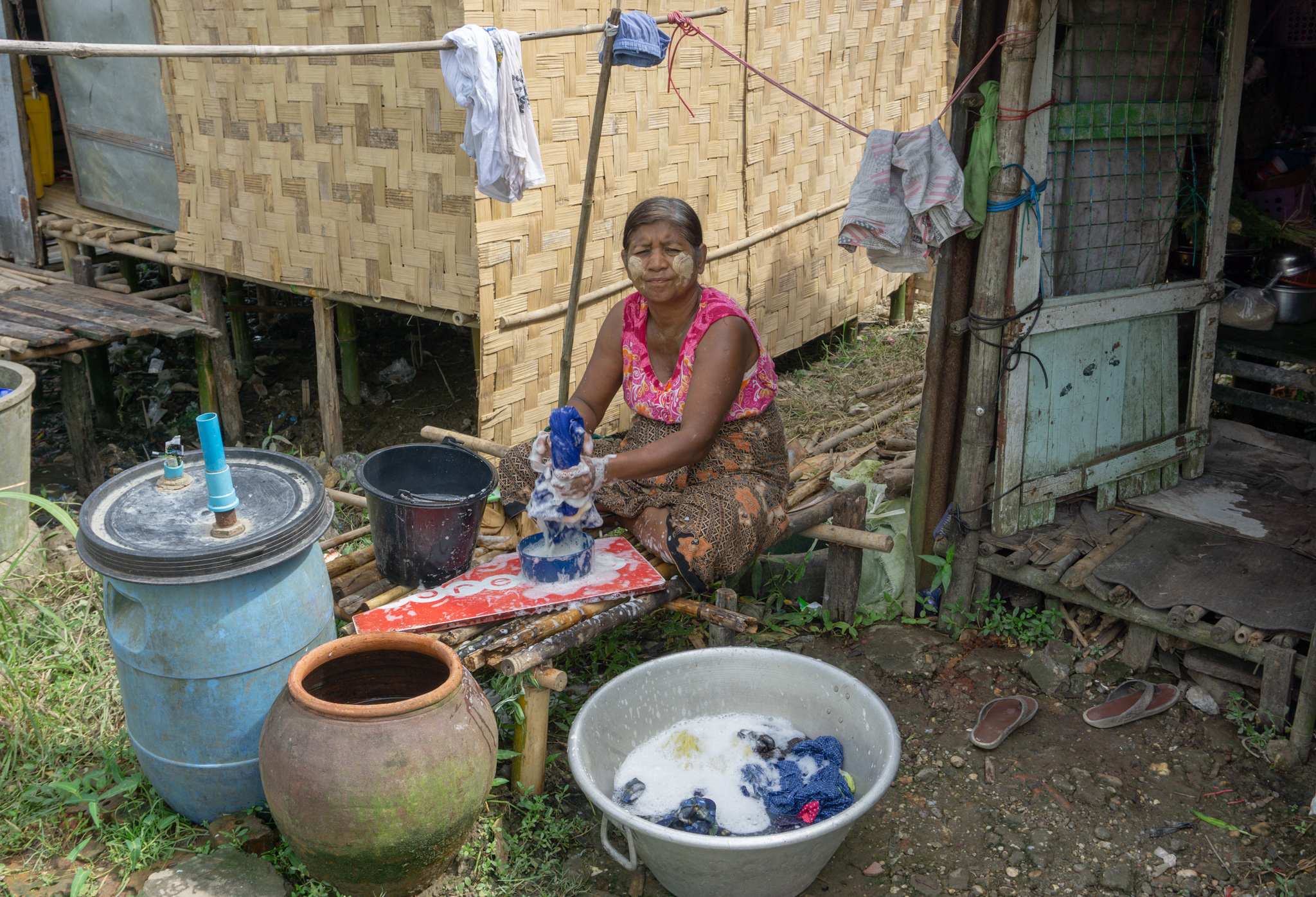 Frau wäscht Kleidung in Myanmar